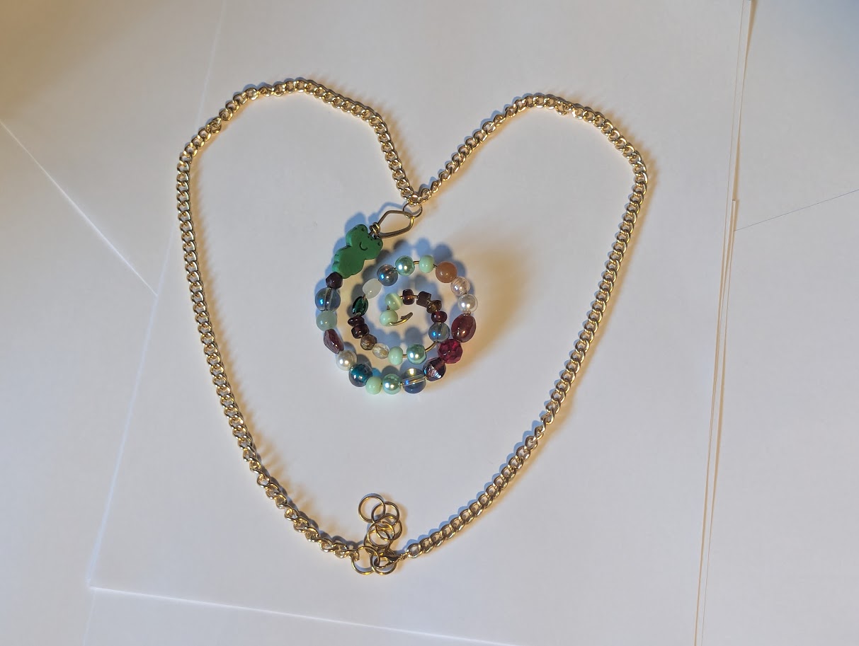 A big spriral of beads on a gold colored chain